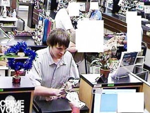 The suspect receiving the money, after threatening the teller.