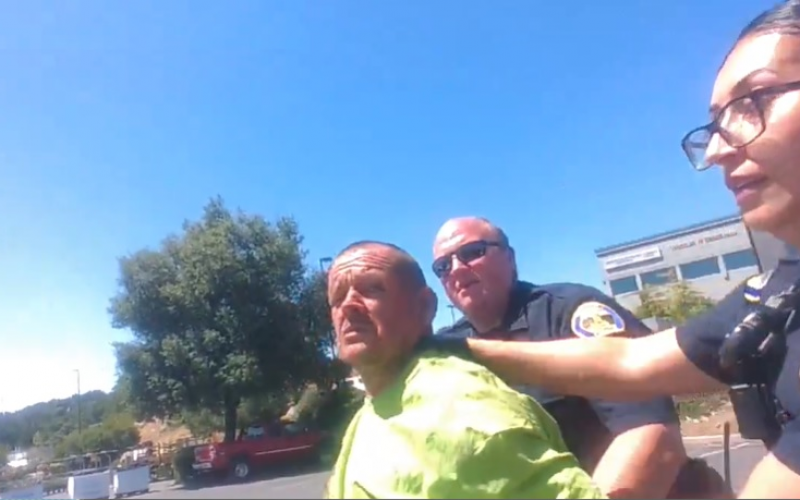 Lying down in a planter box, not wanting to be arrested